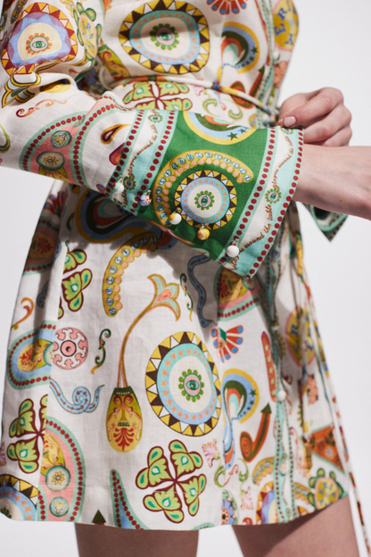Multicolor - Full-length studio shot of a female model wearing a long-sleeved, collared mini shirt dress featuring a colourful paisley print, cinched at the waist with a tie-belt.