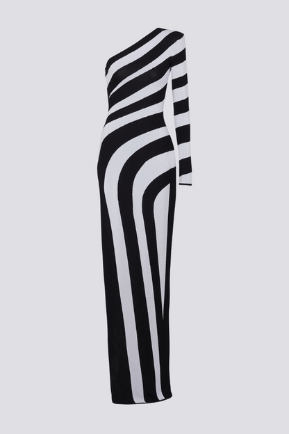 Black - A model stands in profile wearing a form-fitting, one-shoulder maxi dress with a single long sleeve, featuring a bold black and white diagonal stripe pattern and a high thigh slit.