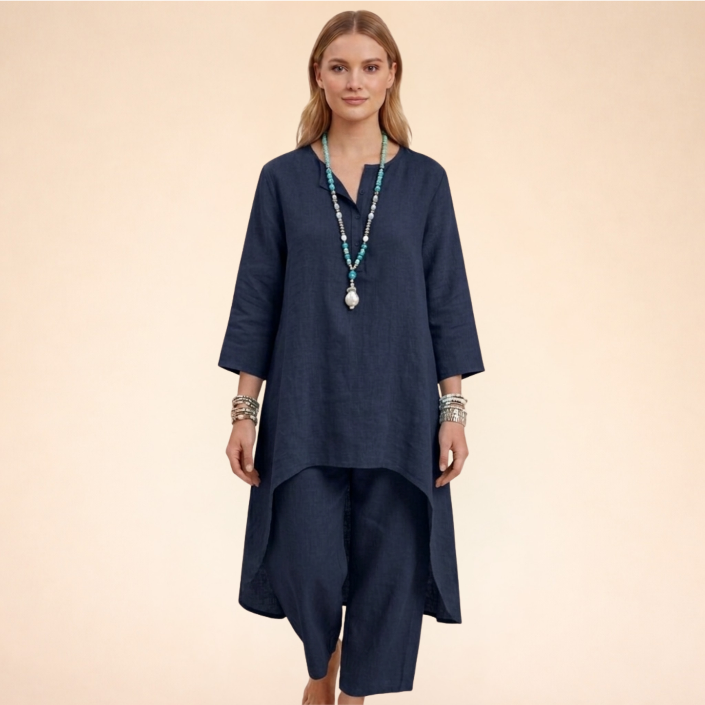 Marineblau - A woman modelling a light-coloured, relaxed-fit resort tunic top featuring a split neckline, three-quarter sleeves, and a dramatic high-low hemline.