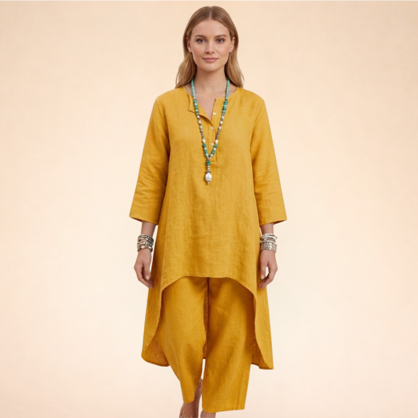 Gelb - A woman modelling a light-coloured, relaxed-fit resort tunic top featuring a split neckline, three-quarter sleeves, and a dramatic high-low hemline.