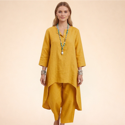 Gelb - A woman modelling a light-coloured, relaxed-fit resort tunic top featuring a split neckline, three-quarter sleeves, and a dramatic high-low hemline.