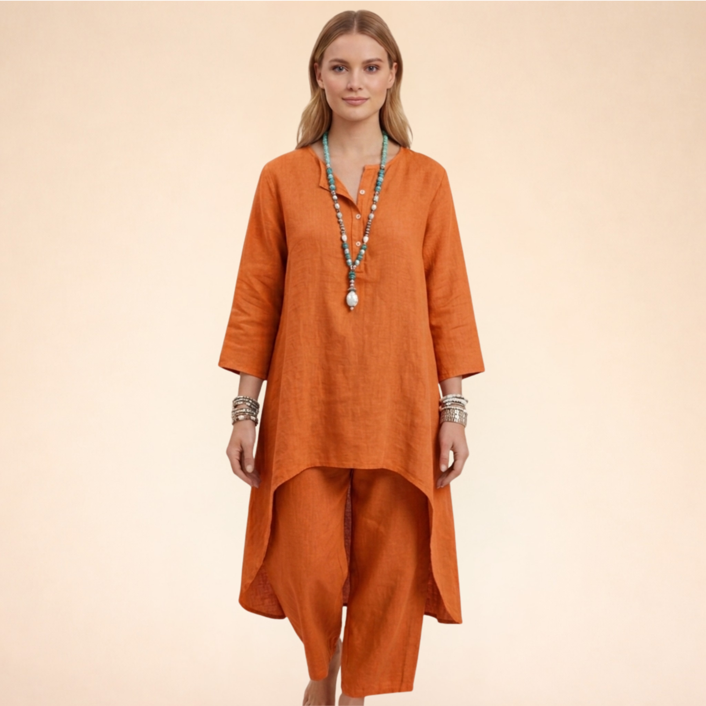 Orange - A woman modelling a light-coloured, relaxed-fit resort tunic top featuring a split neckline, three-quarter sleeves, and a dramatic high-low hemline.