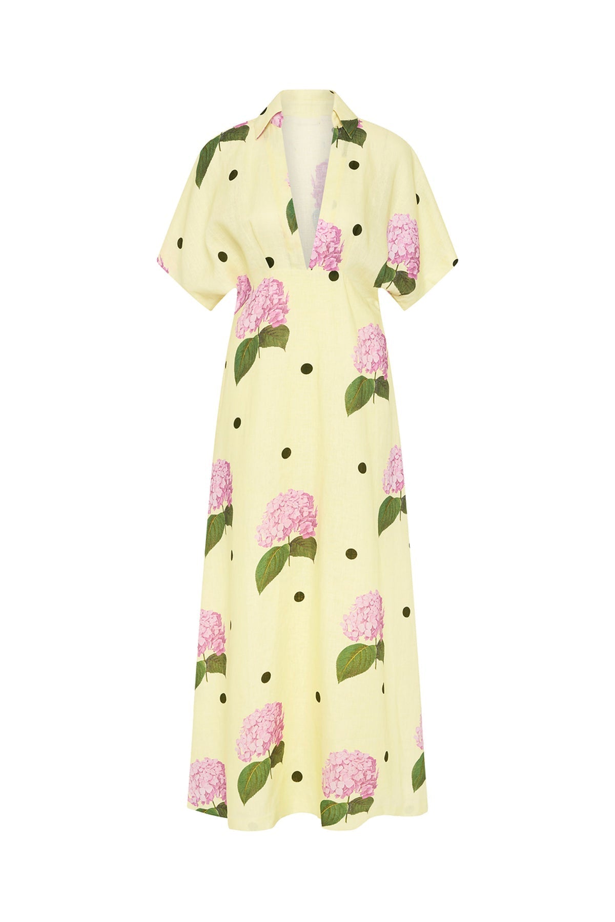 Full-length view of a model wearing a yellow collared maxi dress with short sleeves, a deep V-neck, and a pattern of pink hydrangeas and black polka dots.