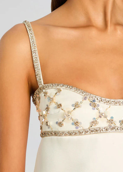 Women's white evening mini dress featuring a structured shift silhouette, slender straps, and a heavily embellished bodice with a sequin lattice pattern.