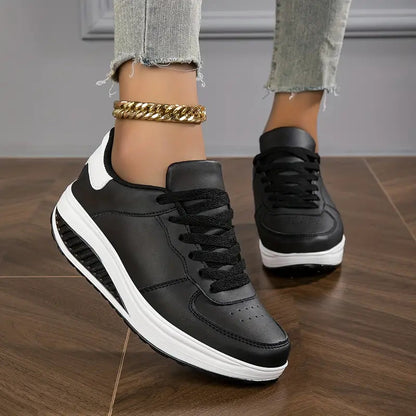 Schwarz - Close-up of a woman's lower legs wearing light wash, slim-fit denim pants featuring a frayed raw hem at the ankle, styled with black platform sneakers and a chunky gold anklet.