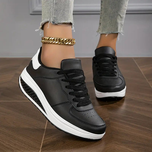 Schwarz - Close-up of a woman's lower legs wearing light wash, slim-fit denim pants featuring a frayed raw hem at the ankle, styled with black platform sneakers and a chunky gold anklet.