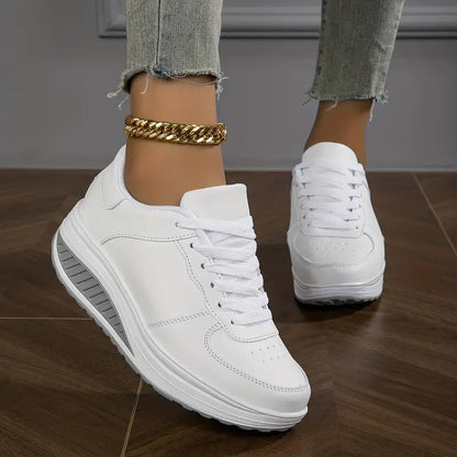 Weiß - Close-up of a woman's lower legs wearing light wash, slim-fit denim pants featuring a frayed raw hem at the ankle, styled with black platform sneakers and a chunky gold anklet.