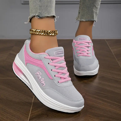 Grau mit Rosa - Close-up of a woman's lower legs wearing light wash, slim-fit denim pants featuring a frayed raw hem at the ankle, styled with black platform sneakers and a chunky gold anklet.