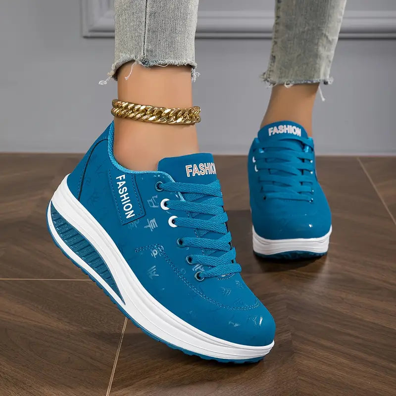 Blau - Close-up of a woman's lower legs wearing light wash, slim-fit denim pants featuring a frayed raw hem at the ankle, styled with black platform sneakers and a chunky gold anklet.
