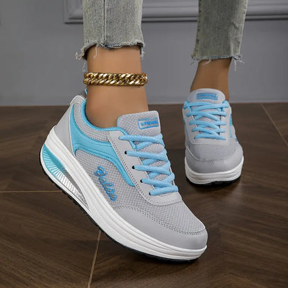 Grau mit Blau - Close-up of a woman's lower legs wearing light wash, slim-fit denim pants featuring a frayed raw hem at the ankle, styled with black platform sneakers and a chunky gold anklet.