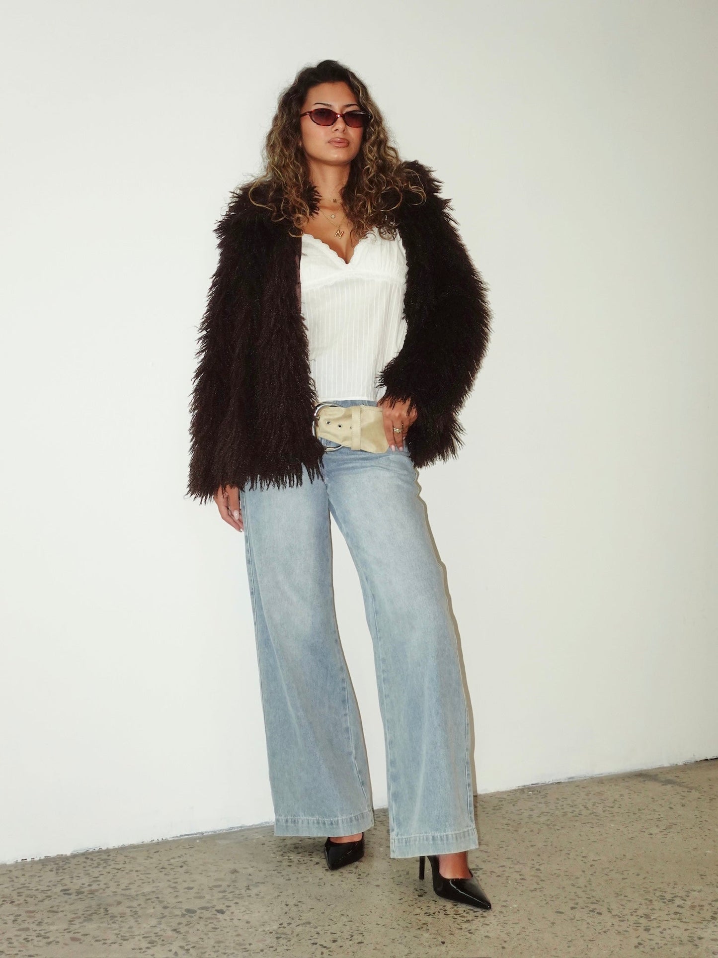 L/XL - Women's cropped shaggy faux fur jacket in a voluminous white texture, styled open over a white crop top and light wash denim jeans.