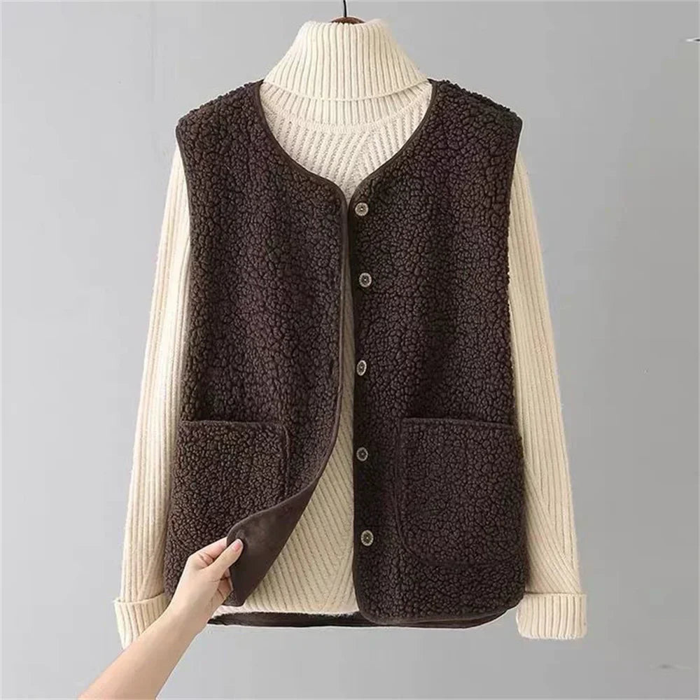 Brown - Three women's faux shearling vests in cream, dark brown, and taupe hanging on wooden hangers, featuring a V-neck, button-front closure, and large patch pockets.