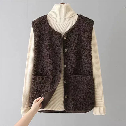Brown - Three women's faux shearling vests in cream, dark brown, and taupe hanging on wooden hangers, featuring a V-neck, button-front closure, and large patch pockets.