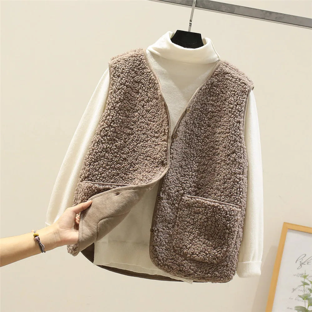 Khaki - Three women's faux shearling vests in cream, dark brown, and taupe hanging on wooden hangers, featuring a V-neck, button-front closure, and large patch pockets.