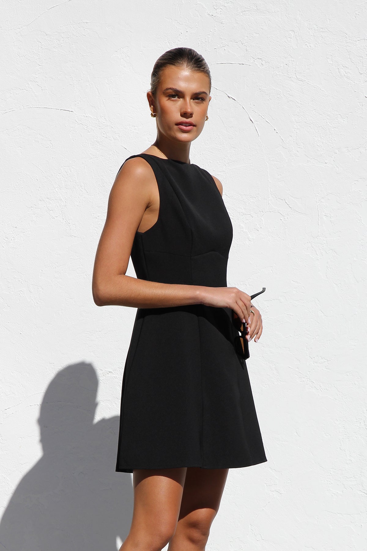 Woman in black crepe A-line mini dress