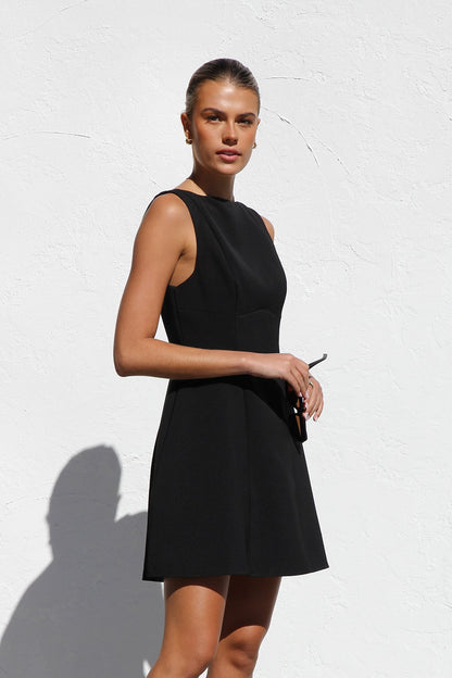 Woman in black crepe A-line mini dress