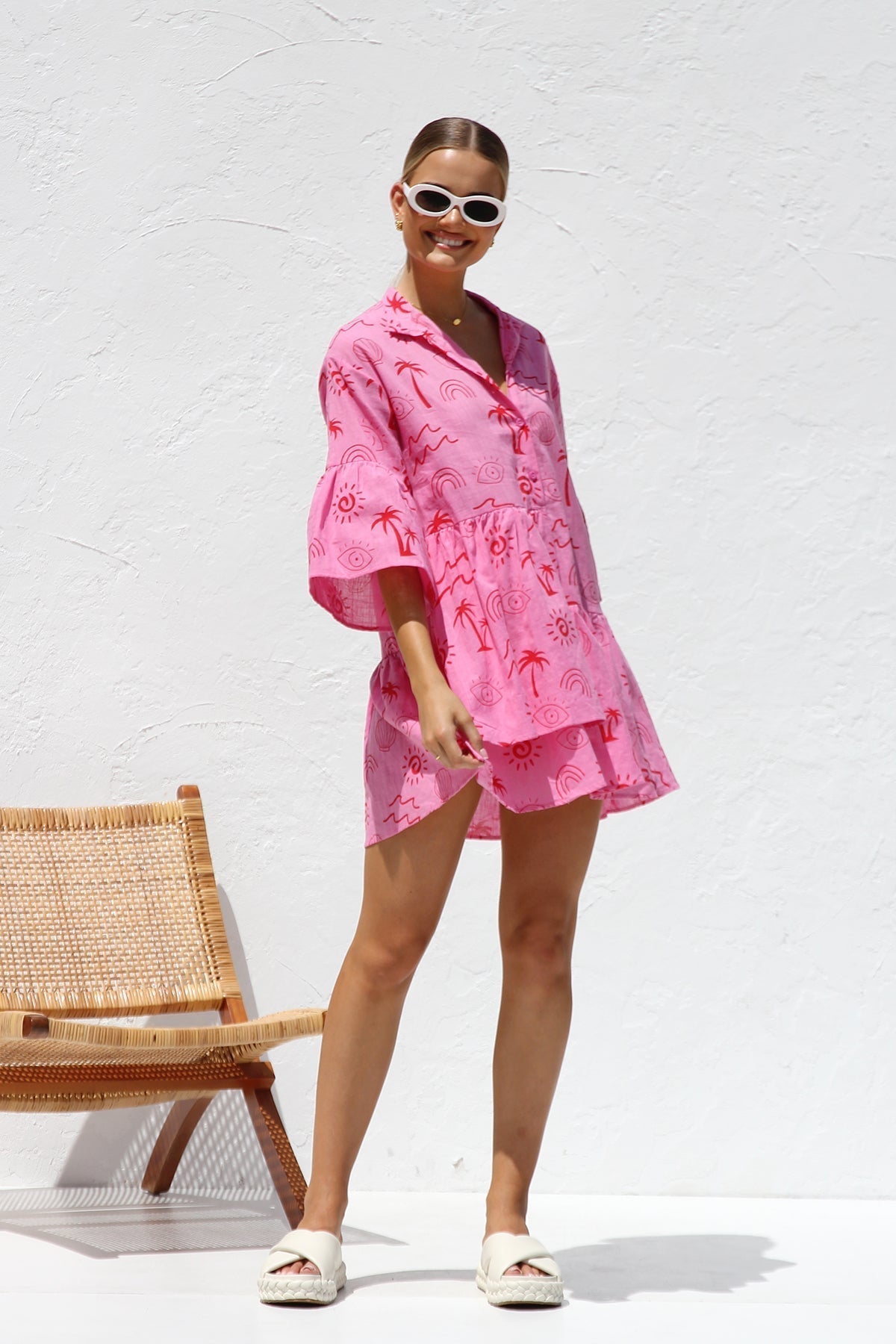 Woman in pink linen mini dress with red print