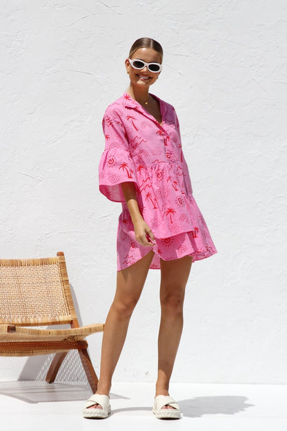 Woman in pink linen mini dress with red print