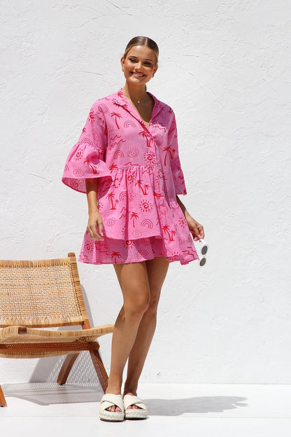 Woman in pink linen mini dress with red print