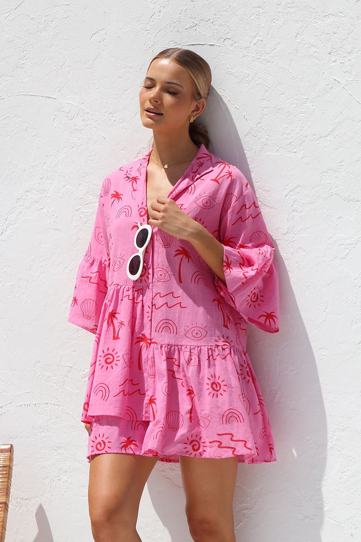 Woman in pink linen mini dress with red print