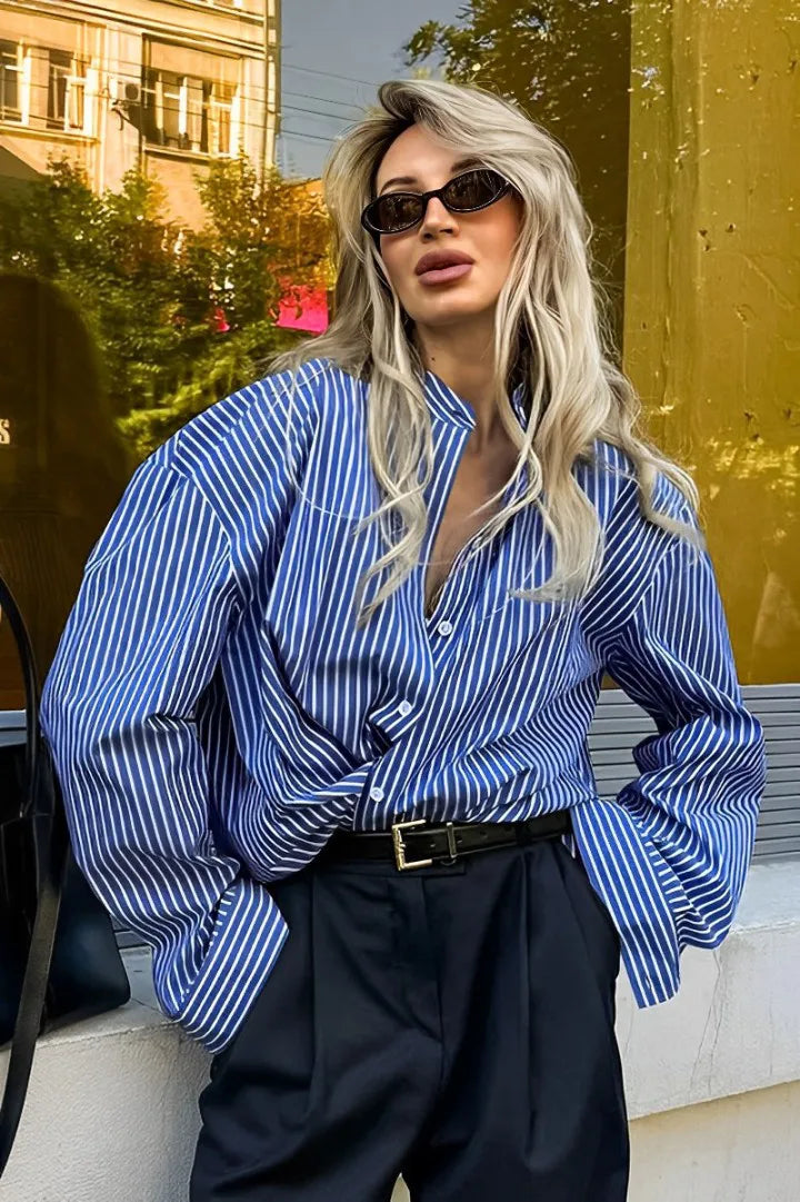 Woman in oversized blue and white striped shirt with black pants