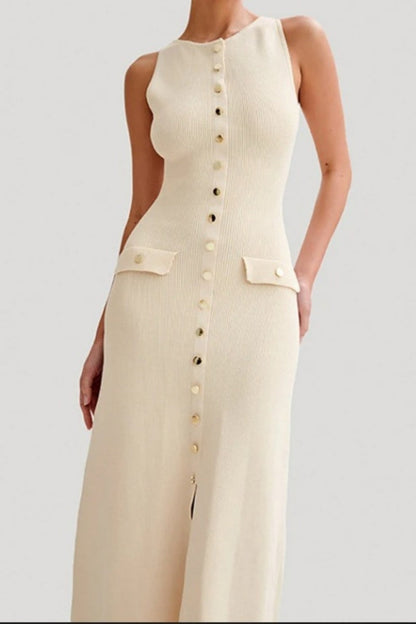 A woman wears a sleeveless, cream-colored ribbed knit midi dress featuring a high neckline, a full front placket of gold-tone buttons, and two small flap pockets at the hips.