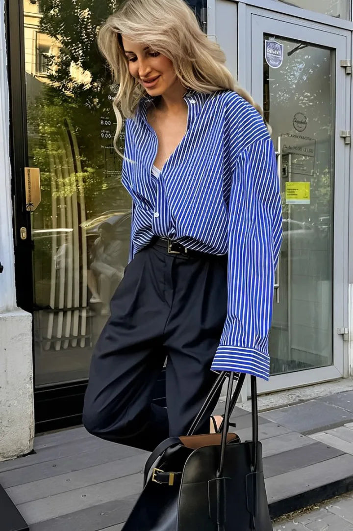Woman in oversized blue and white striped shirt with black pants