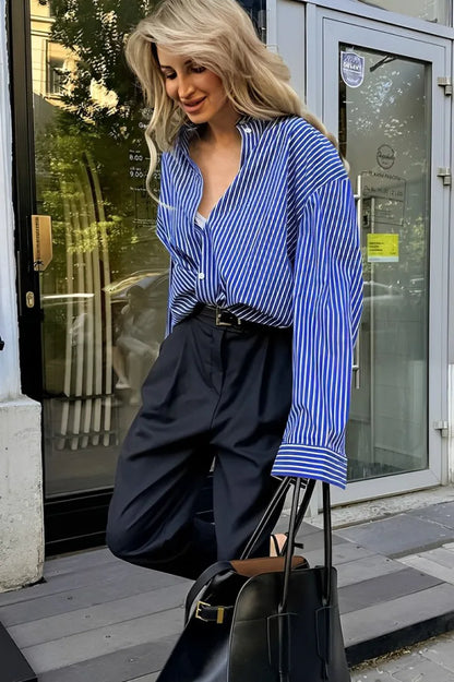 Woman in oversized blue and white striped shirt with black pants