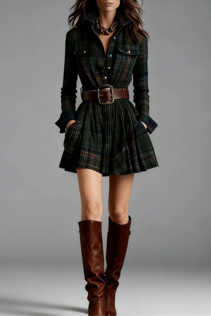 Green - A woman models a long-sleeve, collared mini shirtdress in a multicolor plaid pattern. The dress is cinched with a wide brown belt and features a full, flared skirt, styled with tall brown boots against a grey studio background.