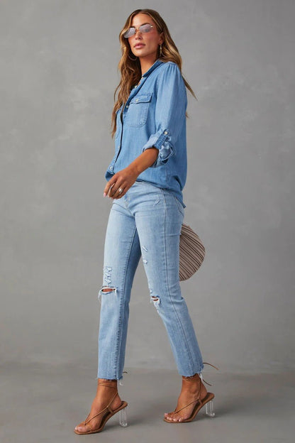 Blue - Women's light blue denim button-down shirt featuring a point collar, dual chest flap pockets, and rolled sleeves secured with button tabs, styled casually.