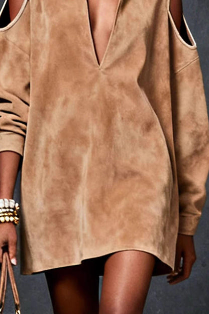 Khaki - A model wears a tan, long-sleeve, suede-finish mini tunic dress with a deep V-neck, a pointed collar, and cutouts at the shoulders. She is accessorized with gold jewelry and carries a brown handbag.