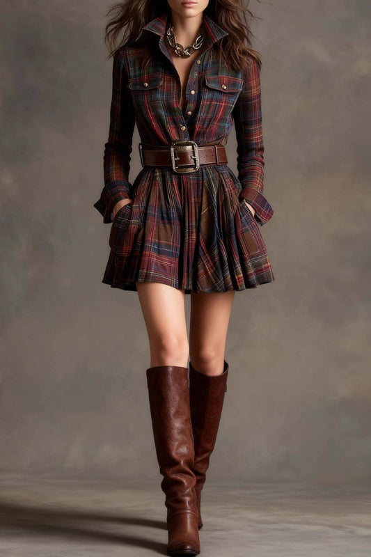 A woman models a long-sleeve, collared mini shirtdress in a multicolor plaid pattern. The dress is cinched with a wide brown belt and features a full, flared skirt, styled with tall brown boots against a grey studio background.