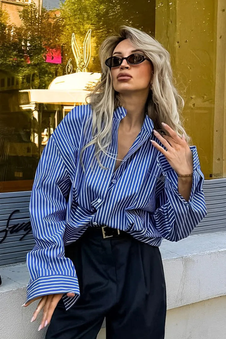 Woman in oversized blue and white striped shirt with black pants