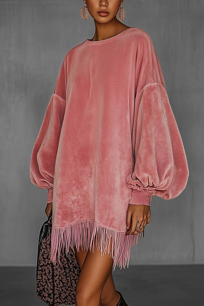 Pink - Model wearing an oversized pink textured mini dress with voluminous balloon sleeves, smocked cuffs, and a long fringed hem.