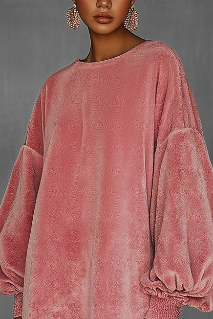 Pink - Model wearing an oversized pink textured mini dress with voluminous balloon sleeves, smocked cuffs, and a long fringed hem.