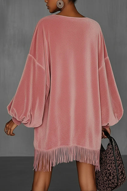 Pink - Model wearing an oversized pink textured mini dress with voluminous balloon sleeves, smocked cuffs, and a long fringed hem.
