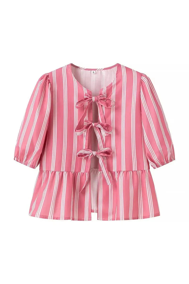Woman in pink and white striped blouse with bow-tie detail