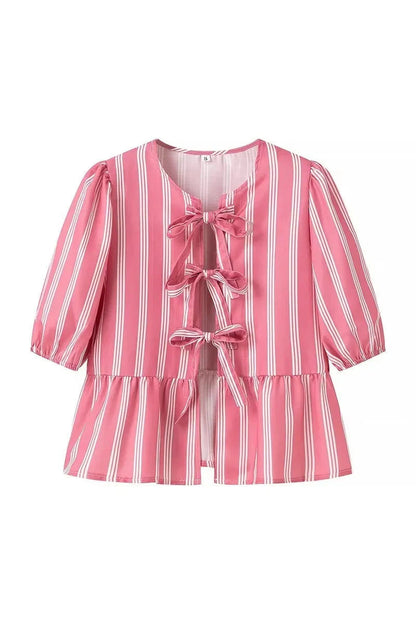 Woman in pink and white striped blouse with bow-tie detail