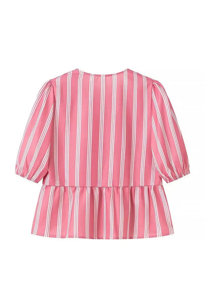 Woman in pink and white striped blouse with bow-tie detail