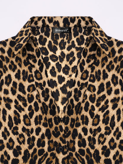 Brown - A woman wearing a long-sleeved, collared, tie-front blouse in a brown and black leopard print, paired with black pants.