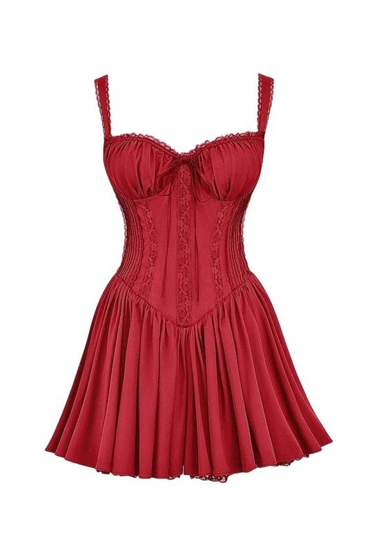 A woman stands in a sunlit vineyard wearing a vibrant red mini dress featuring a structured corset bodice, a ruched sweetheart neckline with a tie-front, wide shirred straps, and a full, flared skirt.
