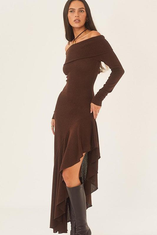 Brown - A woman models a long-sleeved, off-the-shoulder midi dress in a rich chocolate brown. The dress features a form-fitting bodice and a dramatic asymmetrical hemline with cascading ruffles, styled with black high-heeled boots.