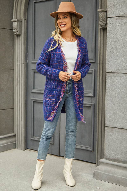 Women's longline open-front knit cardigan featuring a multicolored plaid pattern, fuzzy brushed texture, front patch pockets, and fringe trim along the edges.