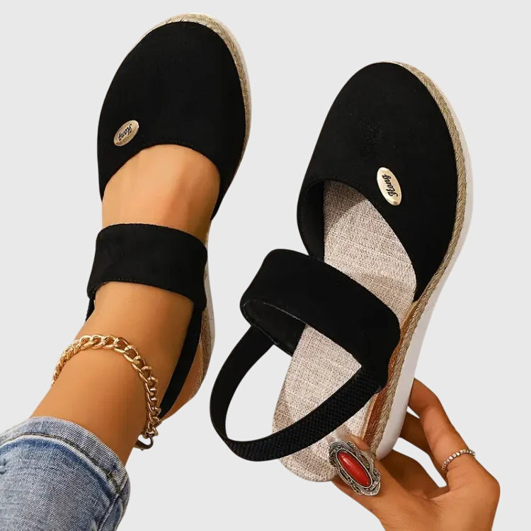Black - Women's canvas platform sandals featuring an elastic slingback strap, braided jute trim, and a metallic logo accent on a thick cushioned sole.