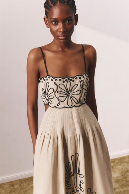Woman in beige linen midi dress with black embroidery