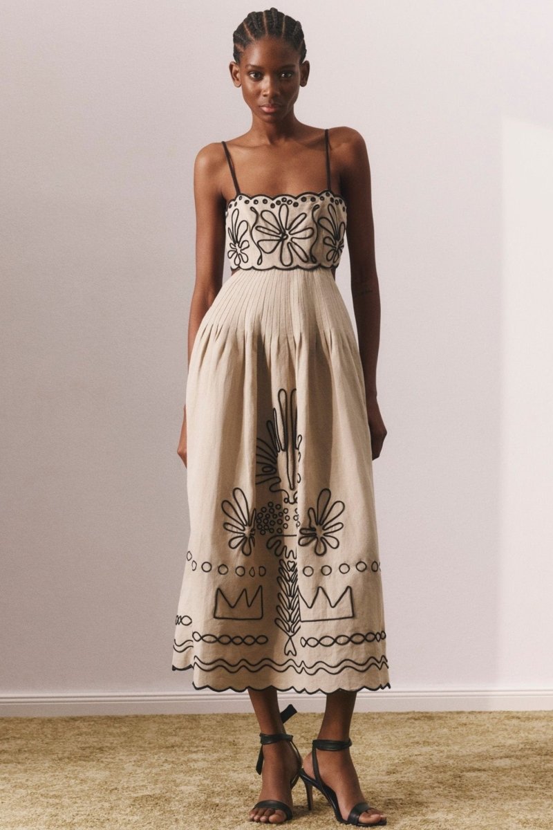 Woman in beige linen midi dress with black embroidery