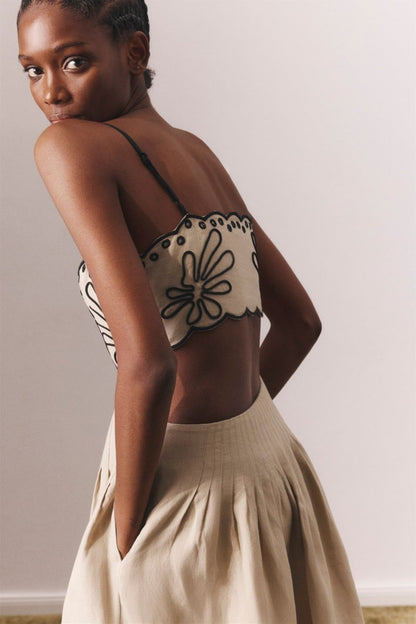 Woman in beige linen midi dress with black embroidery