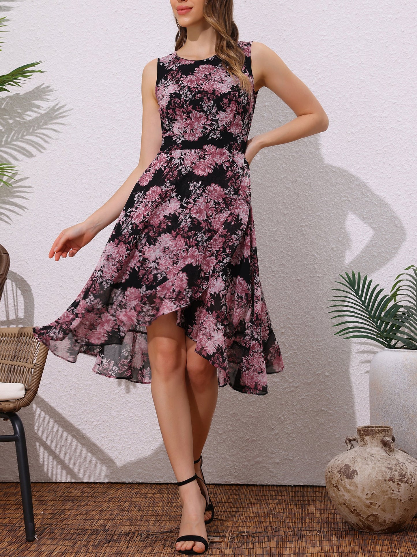 Black - Woman walking outdoors wearing a sleeveless floral chiffon midi sundress with an asymmetrical high-low ruffle hem.