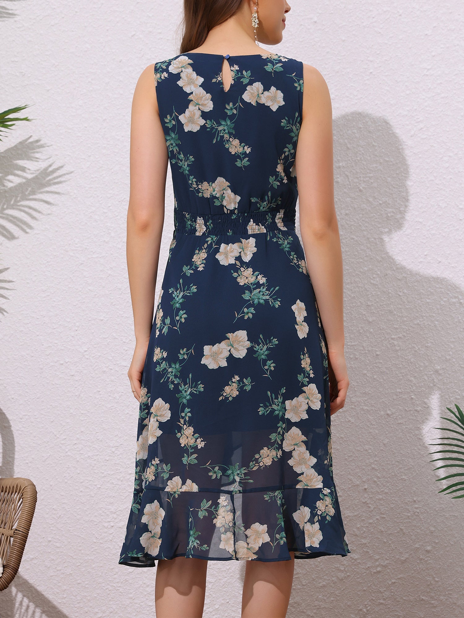 Dark Blue - Woman walking outdoors wearing a sleeveless floral chiffon midi sundress with an asymmetrical high-low ruffle hem.