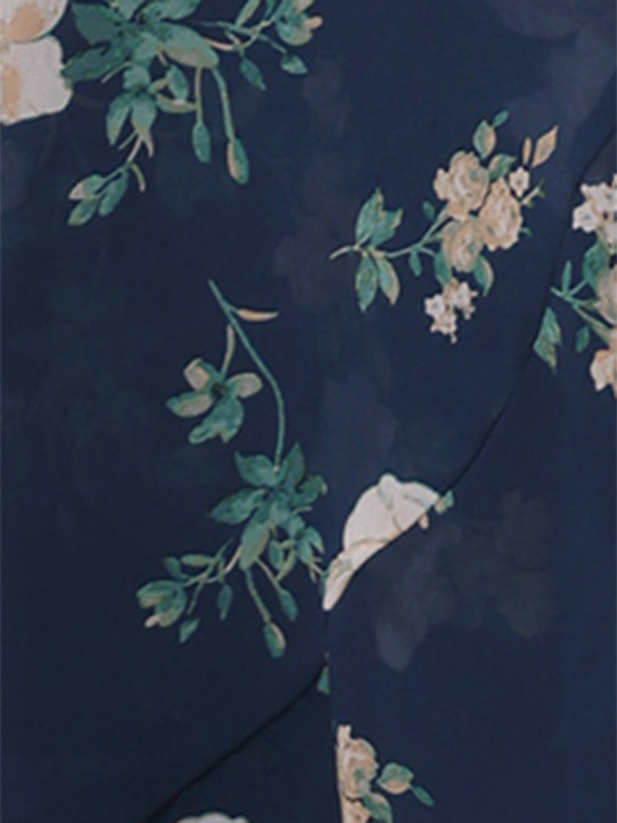 Dark Blue - Woman walking outdoors wearing a sleeveless floral chiffon midi sundress with an asymmetrical high-low ruffle hem.